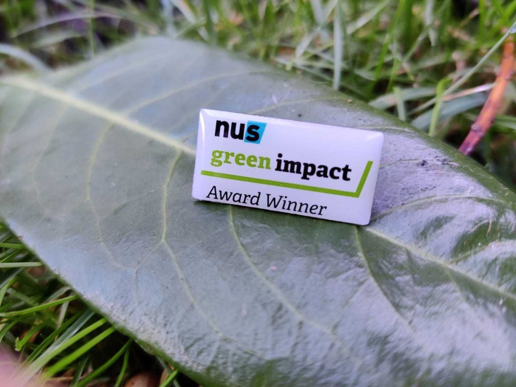 Green Impact award winner pin badge on a leaf